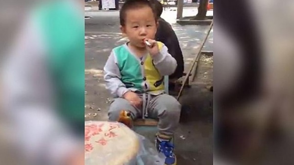 タバコを手放せなくなっている中国の幼児　（画像はnews.com.auのスクリーンショット）