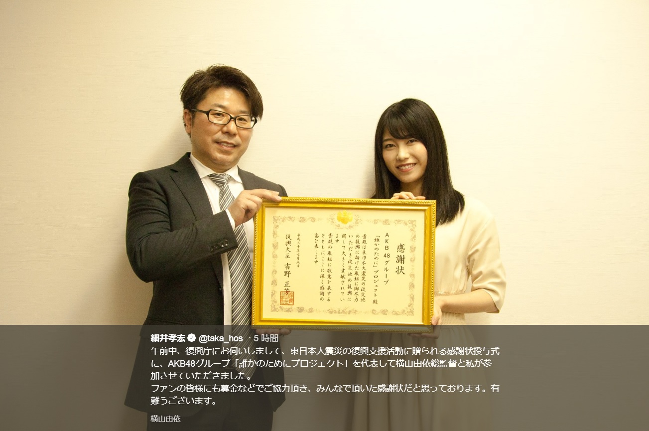 細井孝宏AKB48劇場支配人と横山由依AKB48グループ総監督（画像は『細井孝宏　2018年7月5日付Twitter「午前中、復興庁にお伺いしまして、東日本大震災の復興支援活動に贈られる感謝状授与式に、AKB48グループ「誰かのためにプロジェクト」を代表して横山由依総監督と私が参加させていただきました。」』のスクリーンショット）