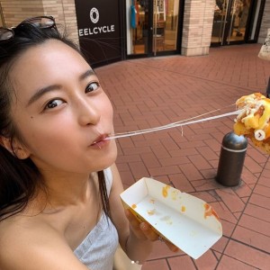 チーズハットグのお決まりのポーズで（画像は『小島瑠璃子　2019年8月16日付Instagram「流行っているものをたべてみました。」』のスクリーンショット）