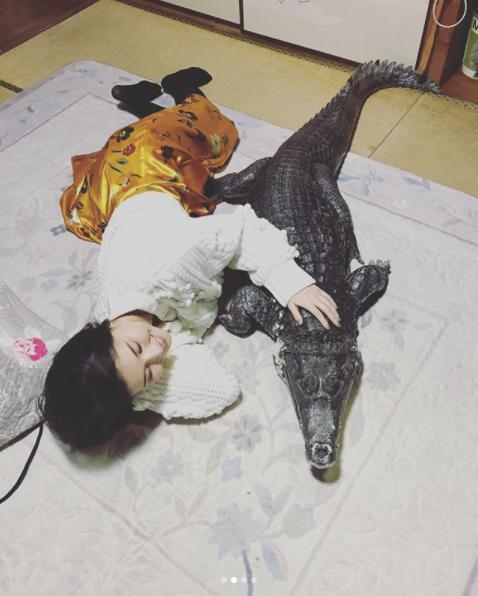 「ワニちゃん」に添い寝する橋本マナミ（画像は『橋本マナミ　2018年3月13日付Instagram「本物です。こたつに入っててかわいい」』のスクリーンショット）