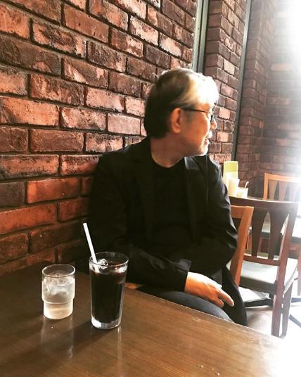 喫茶店でくつろぐ松本隆（画像は『Takashi Matsumoto　2018年5月29日付Instagram「福岡の風街カフェに来てみた。」』のスクリーンショット）