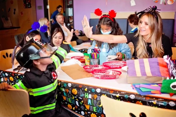 コスチューム姿の子供と仲良くハイファイブ（画像は『Heidi Klum　2018年10月5日付Instagram「What an incredible afternoon at ＠ChildrensLA celebrating Halloween Thank you ＠PartyCity for the amazing costumes and arts ＆ crafts!」』のスクリーンショット）