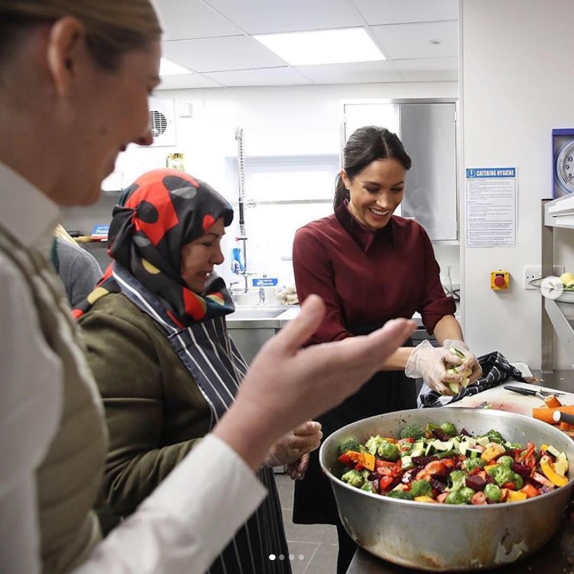腕まくりをして料理を手伝うメーガン妃（画像は『Kensington Palace　2018年11月21日付Instagram「The Duchess of Sussex visited the Hubb Community Kitchen to join the preparations as the women cooked 300 meals for the local community」』のスクリーンショット）
