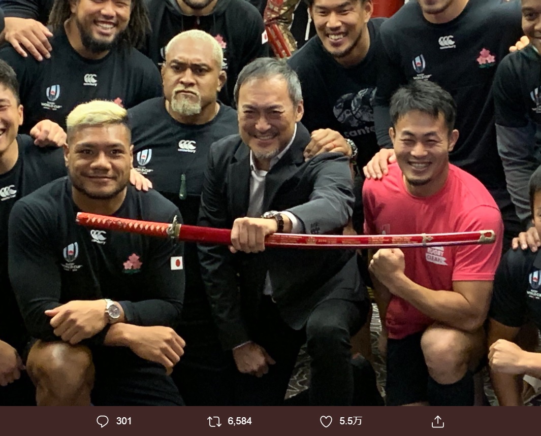 前列左からレメキ ロマノ ラヴァ、渡辺謙、福岡堅樹（画像は『Kenki Fukuoka/福岡 堅樹　2019年10月20日付Twitter「試合前日には渡辺謙さんが、激励に来てくださいました。」』のスクリーンショット）