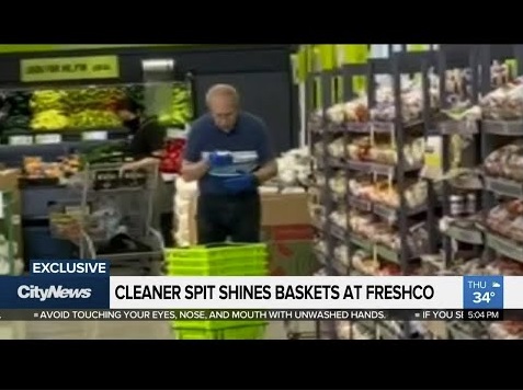 タオルに唾をかける男性スタッフ（画像は『680 NEWS　2020年7月9日公開 YouTube「EXCLUSIVE: Cleaner ‘spit shines’ grocery baskets at Toronto FreshCo」』のサムネイル）