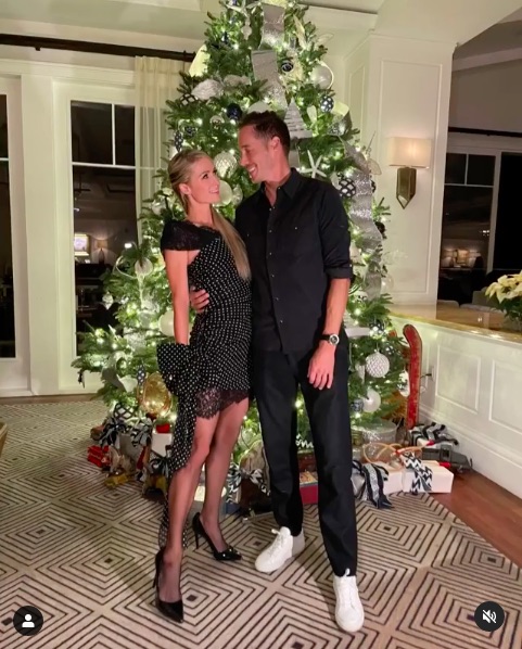 クリスマスツリーの前でパリスと恋人のカーター・リウム氏（画像は『Paris Hilton　2020年12月12日付Instagram「My Christmas wish came true!」』のスクリーンショット）