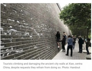 遺跡の壁によじ登る少女（画像は『South China Morning Post 2021年5月6日付「China embarrassed by badly behaving tourists at Xian and Buddhist Shaolin Temple during May Day holiday period」（Photo: Handout）』のスクリーンショット）