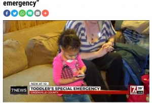携帯電話を手にするアリーヤちゃん（画像は『WSPA　2016年3月3日付「Toddler calls Greenville 911 with “pants emergency”」』のスクリーンショット）