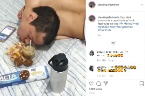 横になったまま食事をするクラウディオさん（画像は『Claudio Vieira　2021年5月23日付Instagram「Deus dará autonomia e capacidade p/ você fazer tudo na vida.」』のスクリーンショット）