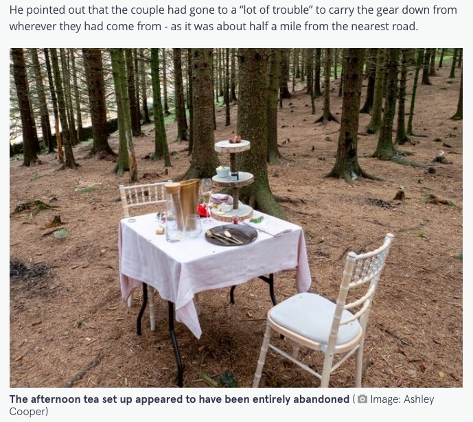 森の中に忽然と現れたテーブルセット（画像は『The Mirror　2021年10月15日付「Mysterious abandoned afternoon tea with bubbles and cheese discovered in UK woodland」（Image: Ashley Cooper）』のスクリーンショット）