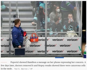 携帯に文字を打ってプラスチックの板越しに伝えたナディアさん（画像は『TODAY　2022年1月4日付「Pre-med student spots cancerous mole on hockey staffer at game. It was a dangerous melanoma」（Ted S. Warren / AP）』のスクリーンショット）