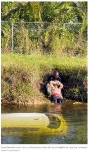 女性を岸に引き上げる近隣住民の男性（画像は『New York Post　2022年11月1日付「Video captures paraglider save Florida woman after car plunged into canal」（Instagram / ＠cristianopiquet）』のスクリーンショット）