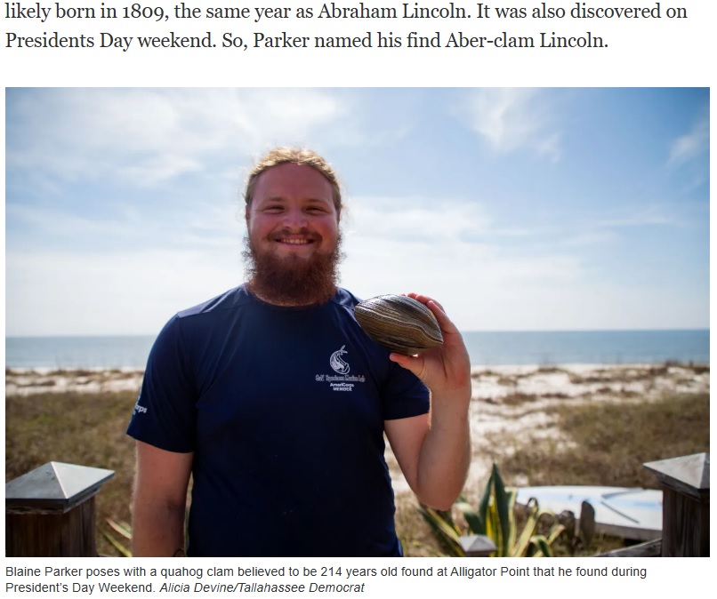 手のひらに収まり切らないほど大きな貝を持つ発見者の男性（画像は『Tallahassee Democrat　2023年2月27日付「Clam believed to be 200+ years old ― named ‘Aber-clam Lincoln’ ― found at Alligator Point」（Alicia Devine/Tallahassee Democrat）』のスクリーンショット）