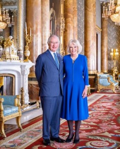 バッキンガム宮殿の公式SNS「The Royal Family」が公開した、ジョージ5世の肖像画の前で寄り添って立つチャールズ国王とカミラ王妃（画像は『The Royal Family　2023年4月28日付Instagram「One week to go!」』のスクリーンショット）