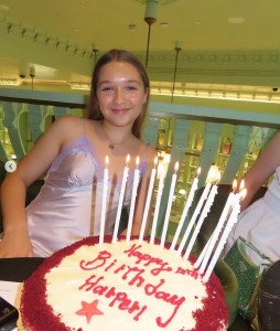 巨大なバースデーケーキを前に微笑むハーパーちゃん。12本の長いキャンドルが飾られている（画像は『Victoria Beckham　2023年7月8日付Instagram「Harper Seven is 12!!」』のスクリーンショット）