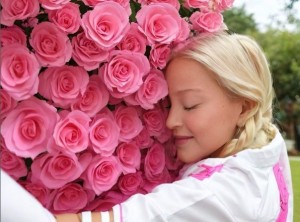 巨大なピンクのバラの花束に寄り添うマドンナ。目を閉じながら、幸せそうに微笑んでいる（画像は『Madonna　2023年7月18日付Instagram「“A single rose can be my garden A single friend my world.”」』のスクリーンショット）