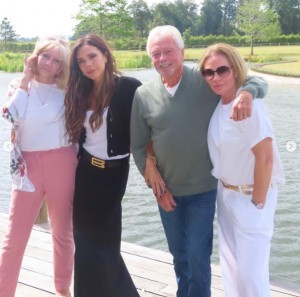 湖畔で寄り添いポーズを取るヴィクトリア・ベッカムの家族。左から母ジャッキーさん、ヴィクトリア、父アンソニーさん、妹ルイーズさん（画像は『Victoria Beckham　2023年7月1日付Instagram「Making memories I love u」』のスクリーンショット）