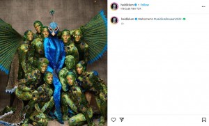 「シルク・ドゥ・ソレイユ」のメンバーとポーズを取るハイディ・クルム。まるで本物の孔雀のような精巧な衣装だ（画像は『Heidi Klum　2023年10月31日付Instagram「Welcome to ＃HeidiHalloween2023」』のスクリーンショット）