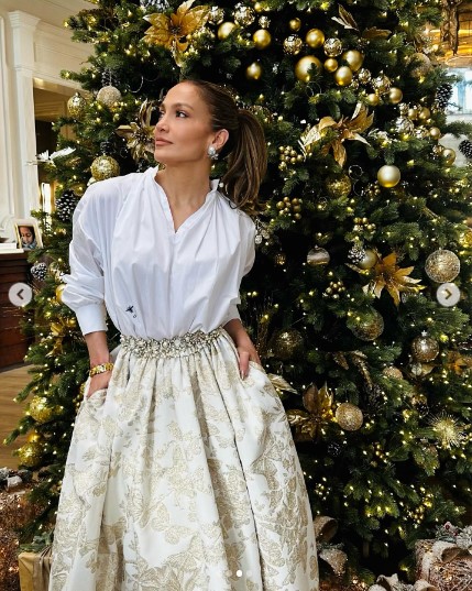 昆虫を刺繍したシャツに蝶柄のスカートを合わせたジェニファー。モミの木に合わせ、自然をイメージしたファッションを選んだとみられる（画像は『Jennifer Lopez　2023年12月12日付Instagram』のスクリーンショット）