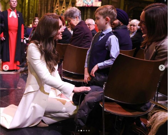 オスカー・バロウ君の目線に合わせ、ひざまずいて会話するキャサリン皇太子妃。オスカー君は英国内で12の山に登り、小児ホスピスのために多額の寄付金を集めた（画像は『The Prince and Princess of Wales　2023年12月18日付Instagram「Such a special evening with ＠earlychildhood here at Westminster Abbey,」』のスクリーンショット）