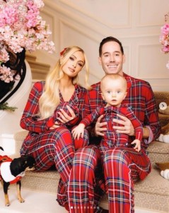 2023年のクリスマスに公開したファミリーショット。カーター氏はフェニックス君を膝に座らせ、パリスはロンドンちゃんを抱いていた（画像は『Paris Hilton　2023年12月25日付Instagram「Merry Christmas from the Hilton-Reums!」』のスクリーンショット）