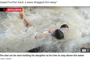 荒れた海で娘をしっかりと抱きしめる父親。近くにいた人々が親子に救命ブイを投げ入れ、現場には救急車4台と救難ヘリコプターが駆けつけた（『The Sun　「WAVE PANIC Shock moment dad leaps from sea wall into torrent after toddler is swept away by huge wave ＆ onlookers watch in horror」（Credit: 7NEWS）』より）