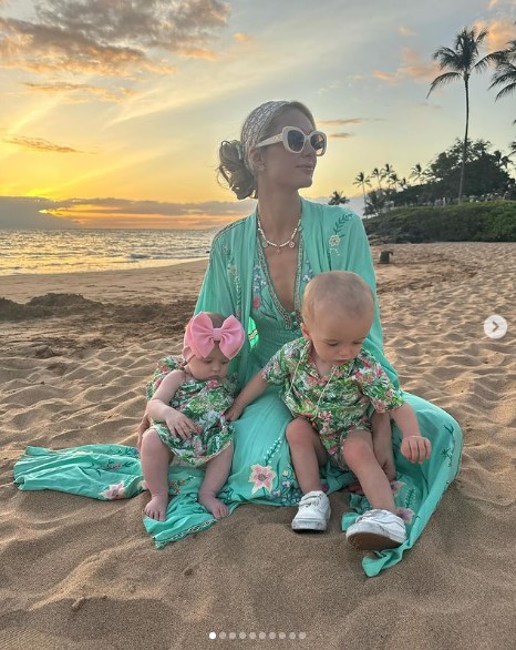 フェニックス君とロンドンちゃんを抱き寄せ、砂浜に座るパリス。子ども達はお揃いのプリント柄の服を着ている（『Paris Hilton　Instagram「Magical Memories at ＠GrandWailea that I will cherish forever」』より）