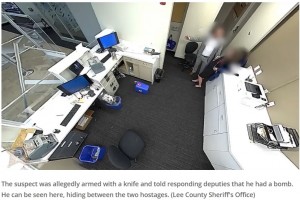 人質2人を盾にして立てこもっていた強盗犯が人質の喉にナイフを当てたため、特殊部隊が動きを見せた（『FOX 35 Orlando　「Florida sniper saves hostages by shooting alleged bank robber through computer monitor: VIDEO」（Lee County Sheriff's Office）』より）